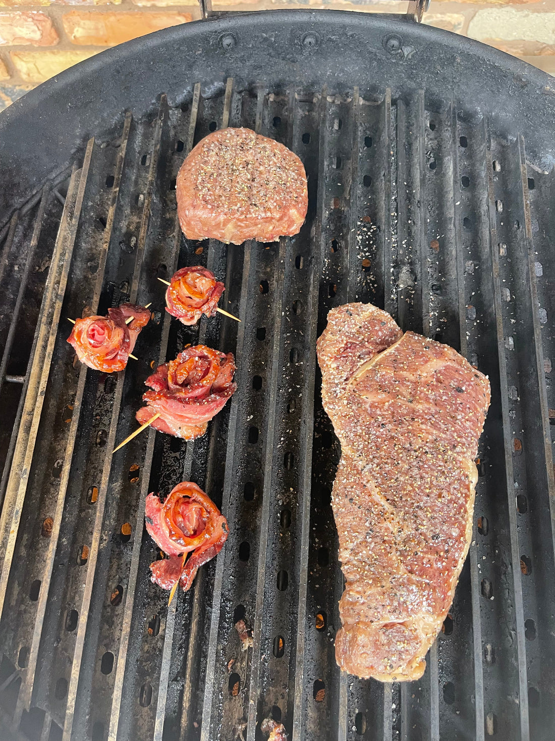 A curated selection of Hassell Cattle Company beef cuts, including new york strip and bacon arranged neatly, both part of the Sweetheart Deal, displayed on a rustic wooden background with a romantic touch