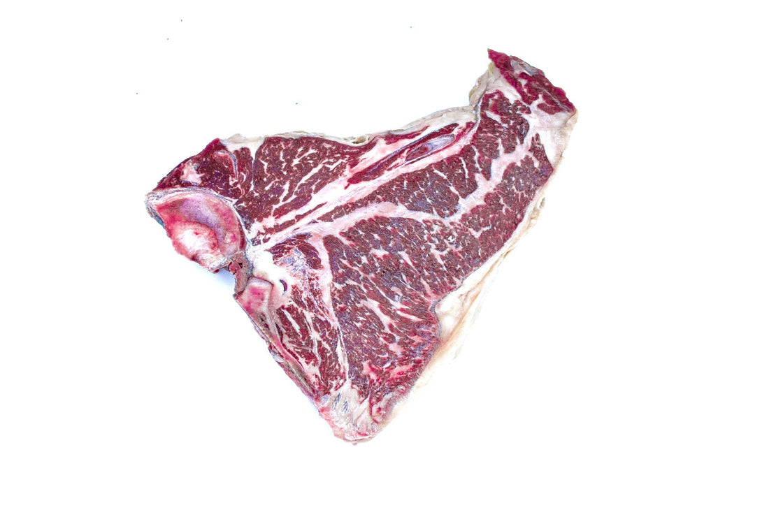A thick, Hassell Cattle Company T-bone steak, showcasing its rich marbling and vibrant red color, placed on a clean, crisp white background.