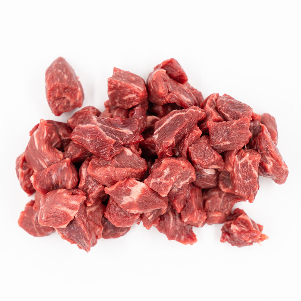 Fresh, neatly cubed Hassell Cattle Company stew meat showcasing rich red marbled beef, placed on a clean white surface.