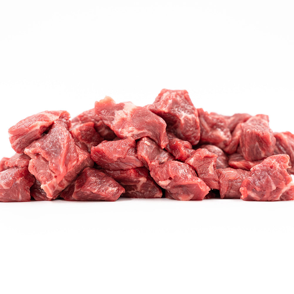 Fresh, neatly cubed Hassell Cattle Company stew meat showcasing rich red marbled beef, placed on a clean white surface.