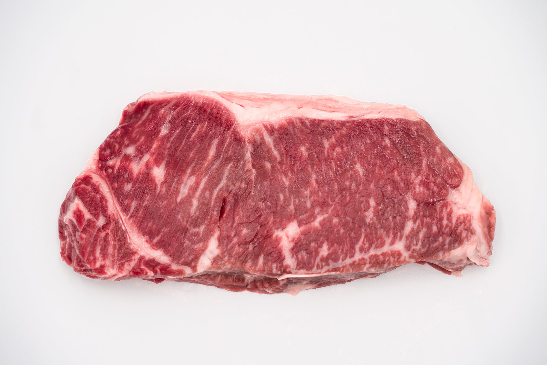 Real Hassell Cattle New York Strip raw product photo.