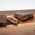 Wagyu New York strip steaks on the butcher block