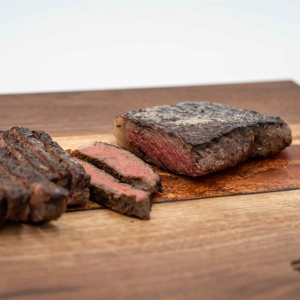 Wagyu New York strip steaks on the butcher block