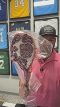 Yehuda holding up a vacuum-sealed Hassell Gold Tomahawk on a live show