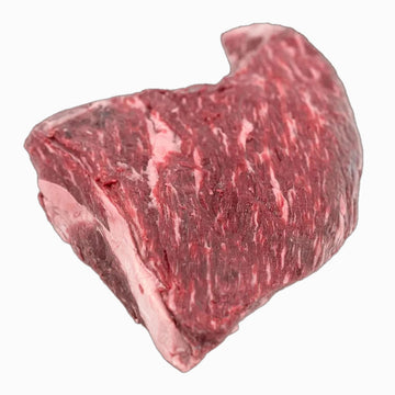 A well-marbled, boneless tri-tip cut of beef, showcasing its tender texture and rich red color, set on a clean, crisp white surface.