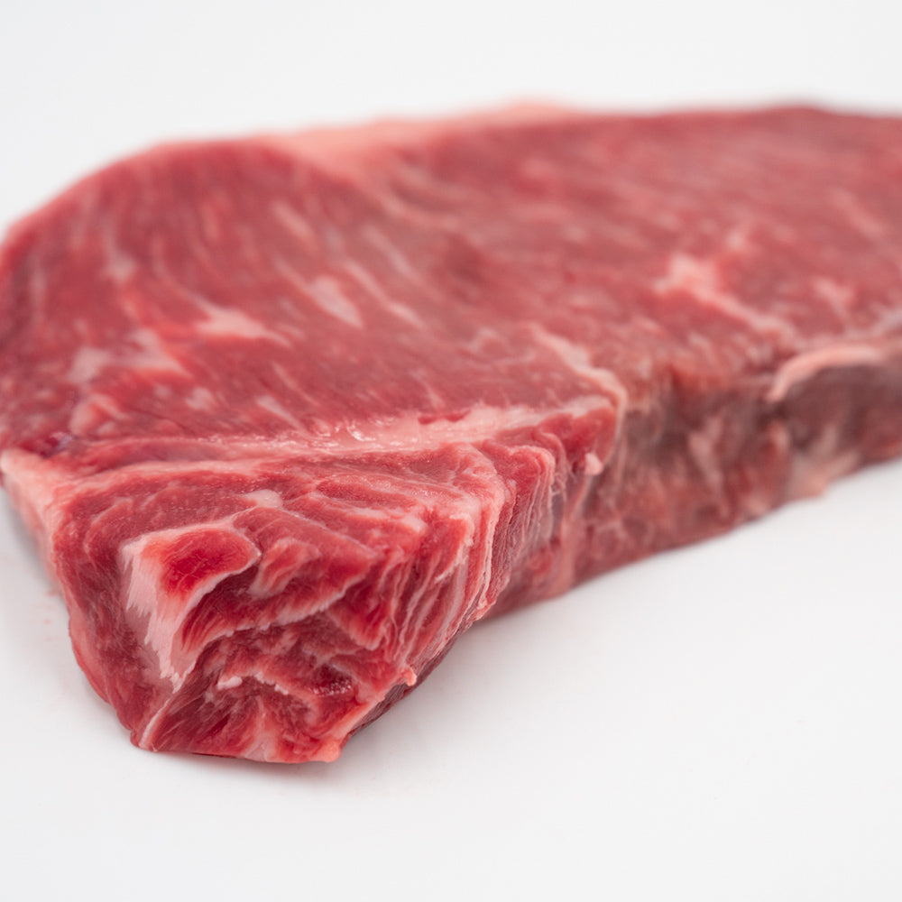 A beautifully marbled New York Strip steak from Hassell Cattle Company, known for its rich flavor and tender texture.