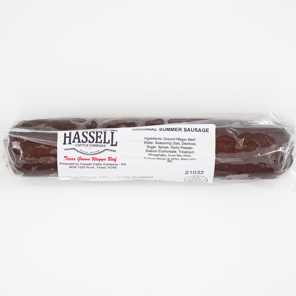 A Hassell Cattle Company summer sausage, showcasing the smoked, rich-colored sausage with a smooth surface, placed on a crisp white background