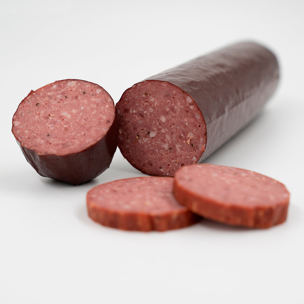 A Hassell Cattle Company summer sausage, showcasing the smoked, rich-colored sausage with a smooth surface, placed on a crisp white background